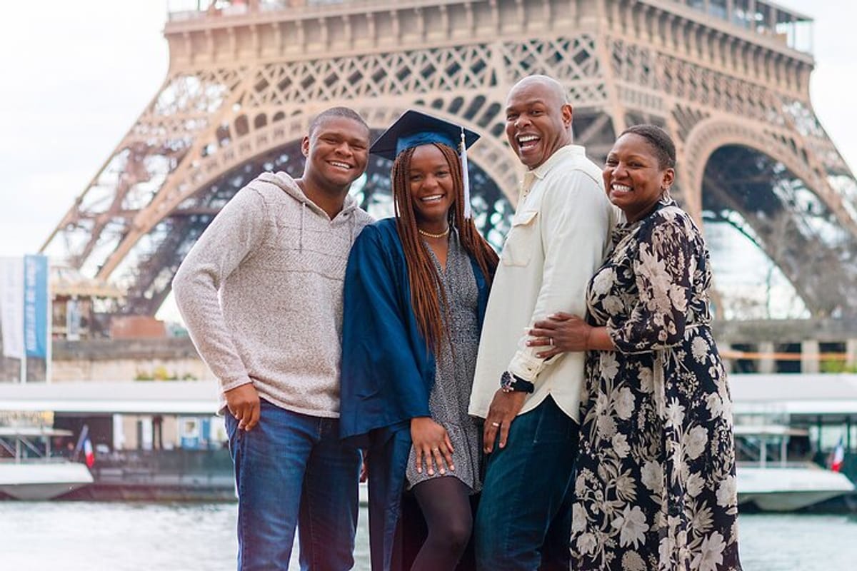 Family with a recent graduate posing in front of the Eiffel Tower in Paris, France